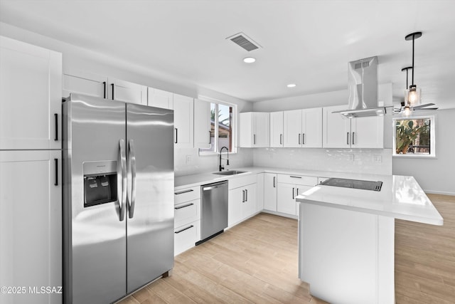 5011 E Scarlett St, Tucson, AZ 85711 - kitchen with stainless steel appliances, island exhaust hood, a sink, light countertops, and white cabinets