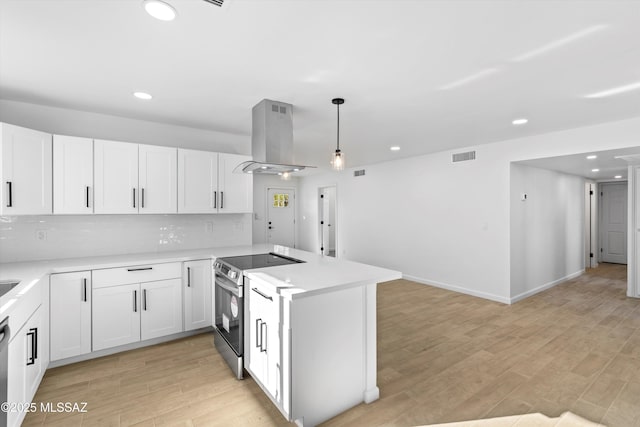 5011 E Scarlett St, Tucson, AZ 85711 - kitchen with electric stove, island exhaust hood, recessed lighting, a peninsula, and light countertops
