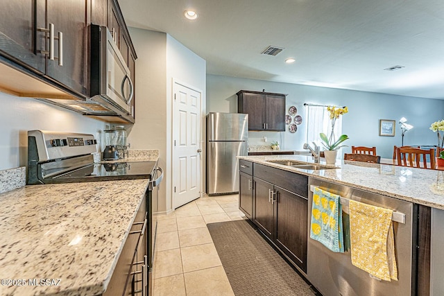 12625 N Wildrose Dr, Marana, AZ 85653 - kitchen with appliances with stainless steel finishes, dark brown cabinets, light tile patterned flooring, light stone countertops, and a sink
