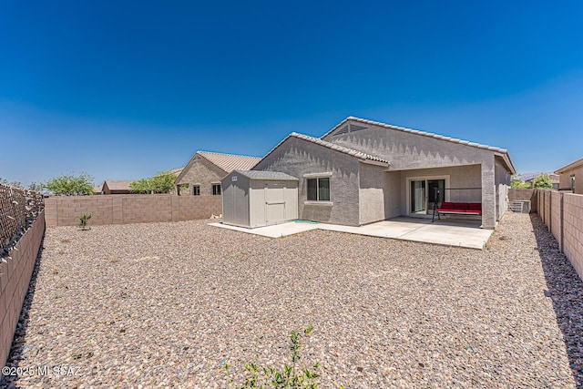 12625 N Wildrose Dr, Marana, AZ 85653 - back of house with a storage shed, stucco siding, a fenced backyard, an outdoor structure, and a patio area