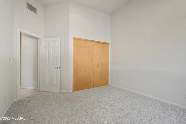 3829 N River Oak Ln, Tucson, AZ 85718 - unfurnished bedroom with carpet flooring, baseboards, a closet, and a high ceiling