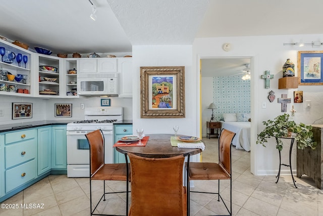 344 S Paseo Sarta Unit C, Green Valley, AZ 85614 - kitchen featuring white appliances, dark countertops, light tile patterned flooring, track lighting, and blue cabinetry