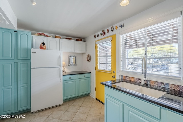 344 S Paseo Sarta Unit C, Green Valley, AZ 85614 - kitchen with freestanding refrigerator, a sink, dark countertops, light tile patterned flooring, and white cabinets