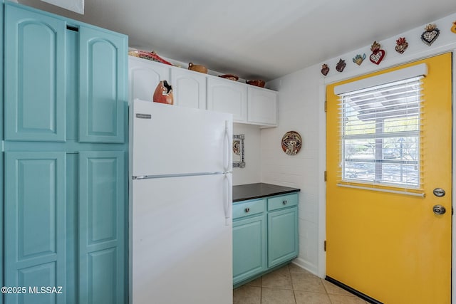 344 S Paseo Sarta Unit C, Green Valley, AZ 85614 - kitchen featuring freestanding refrigerator, light tile patterned floors, dark countertops, and blue cabinetry