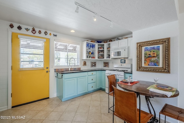 344 S Paseo Sarta Unit C, Green Valley, AZ 85614 - kitchen with white appliances, track lighting, dark countertops, a sink, and open shelves