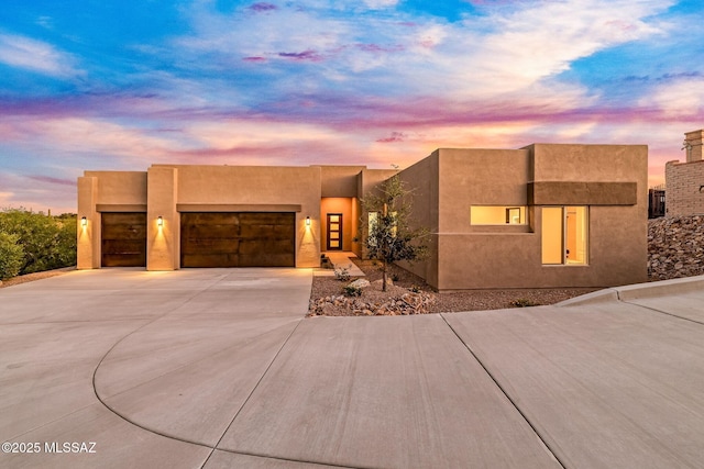 3560 N San Sebastian Dr Unit 12, Tucson, AZ 85750 - pueblo-style house with a garage, concrete driveway, and stucco siding