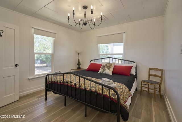 203 N Kellum Ave, Bowie, AZ 85605 - bedroom with a chandelier, wood finished floors, baseboards, and ornamental molding