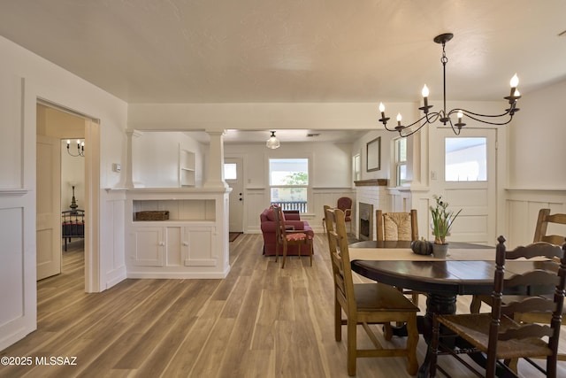 203 N Kellum Ave, Bowie, AZ 85605 - dining area with a decorative wall, wainscoting, wood finished floors, and a chandelier