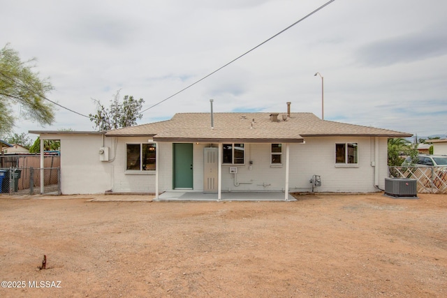 back of property with a patio area, fence, central AC unit, and a shingled roof