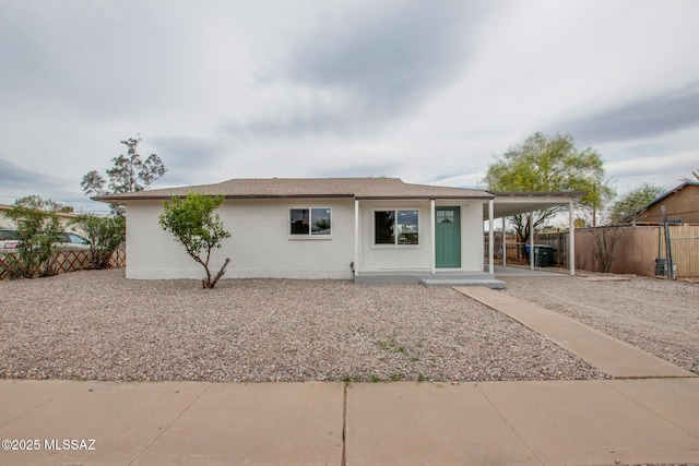 view of front facade featuring fence and a carport