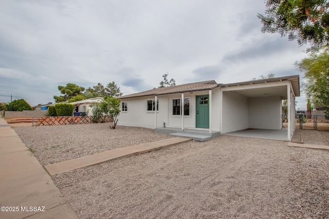 view of front of property with fence, driveway, and an attached carport