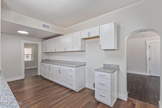 2956 N Tyndall Ave, Tucson, AZ 85719 - kitchen featuring arched walkways, white cabinets, dark wood finished floors, and baseboards