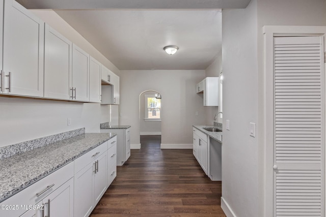 2956 N Tyndall Ave, Tucson, AZ 85719 - kitchen with a sink, light stone countertops, dark wood-type flooring, and baseboards