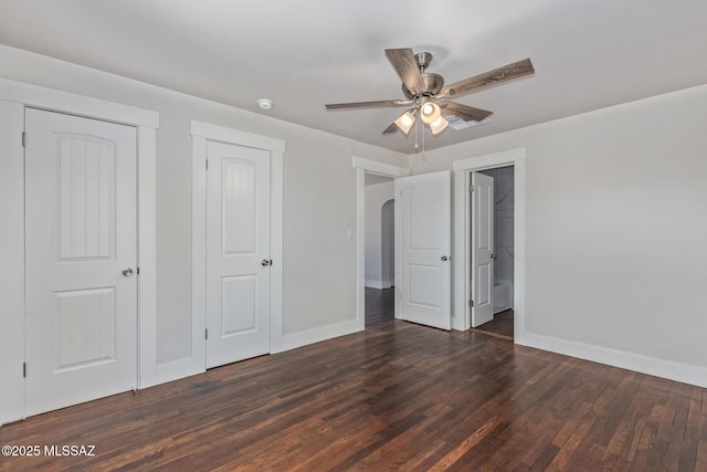 2956 N Tyndall Ave, Tucson, AZ 85719 - unfurnished bedroom with baseboards, wood finished floors, arched walkways, a closet, and a ceiling fan