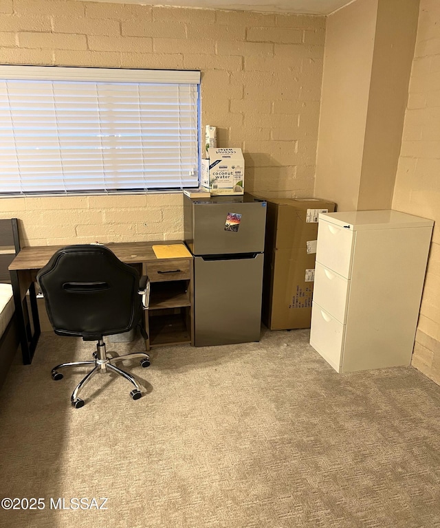 office area with light colored carpet and concrete block wall