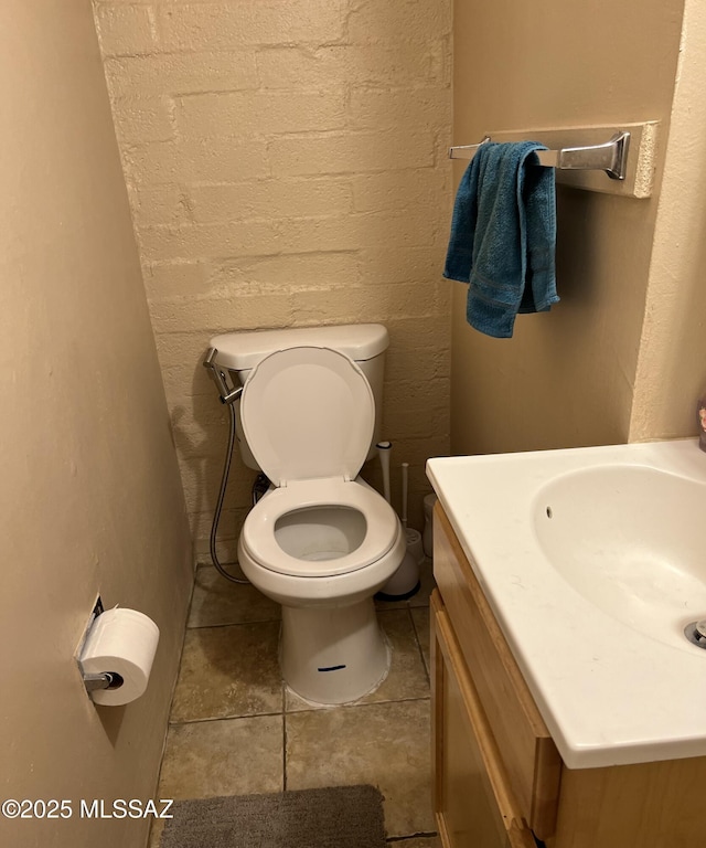 half bath featuring toilet, vanity, and tile patterned floors