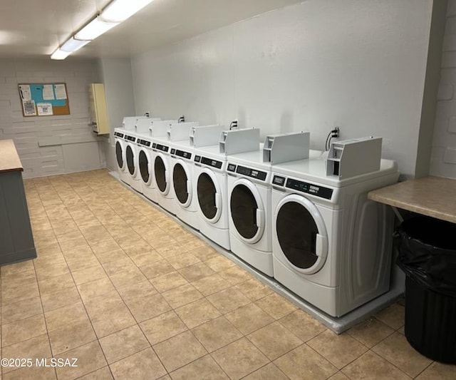 shared laundry with washing machine and dryer and light tile patterned floors