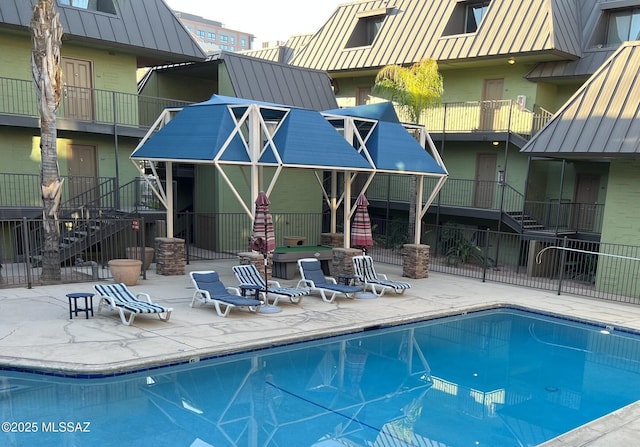view of swimming pool featuring stairway, a patio, and fence