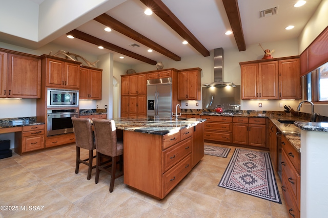 12800 W Arivaca Rd, Amado, AZ 85645 - kitchen with built in appliances, a sink, wall chimney range hood, brown cabinets, and beam ceiling