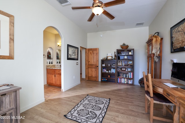 12800 W Arivaca Rd, Amado, AZ 85645 - home office with light wood-type flooring, ceiling fan, arched walkways, and baseboards