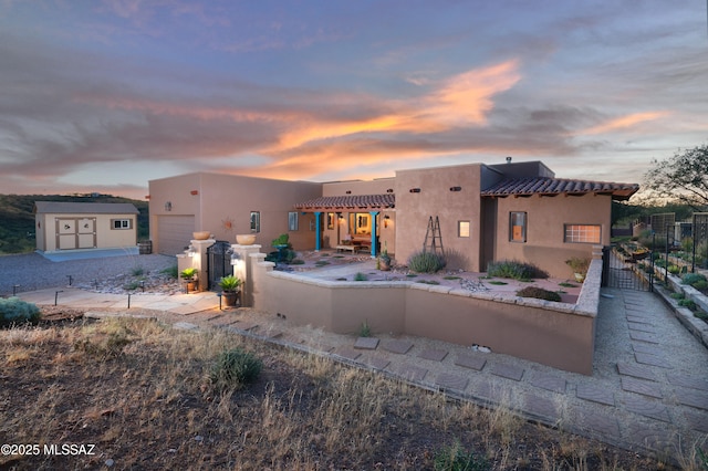 12800 W Arivaca Rd, Amado, AZ 85645 - back of property at dusk featuring stucco siding and an attached garage