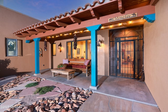 12800 W Arivaca Rd, Amado, AZ 85645 - doorway to property with stucco siding, a patio area, a tile roof, and outdoor lounge area
