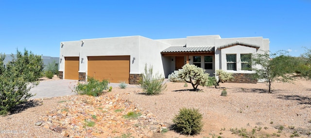 432 N Heritage Point Pl, Sahuarita, AZ 85629 - adobe home featuring an attached garage, stucco siding, stone siding, and driveway