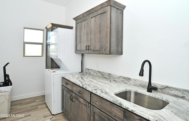 432 N Heritage Point Pl, Sahuarita, AZ 85629 - clothes washing area featuring cabinet space, stacked washer / drying machine, light wood-type flooring, and baseboards