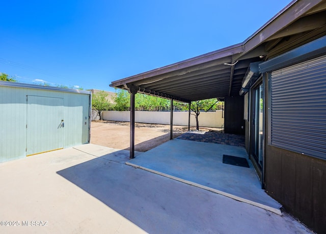 2607 E Adams St, Tucson, AZ 85716 - view of patio featuring an outdoor structure, fence, and a storage unit