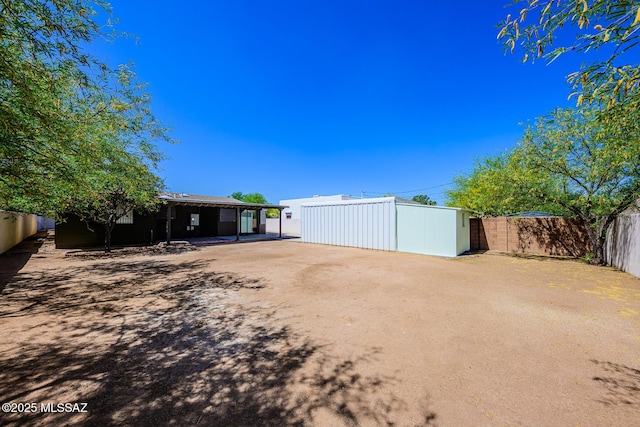 2607 E Adams St, Tucson, AZ 85716 - fenced backyard with dirt driveway and an outdoor structure