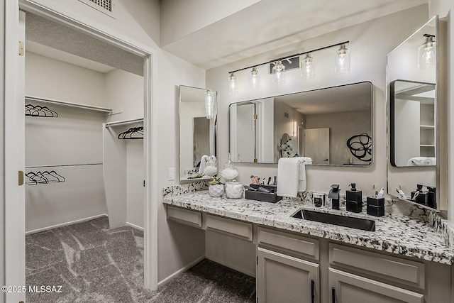 2756 S Via Del Bac, Green Valley, AZ 85622 - bathroom with a walk in closet, vanity, and baseboards