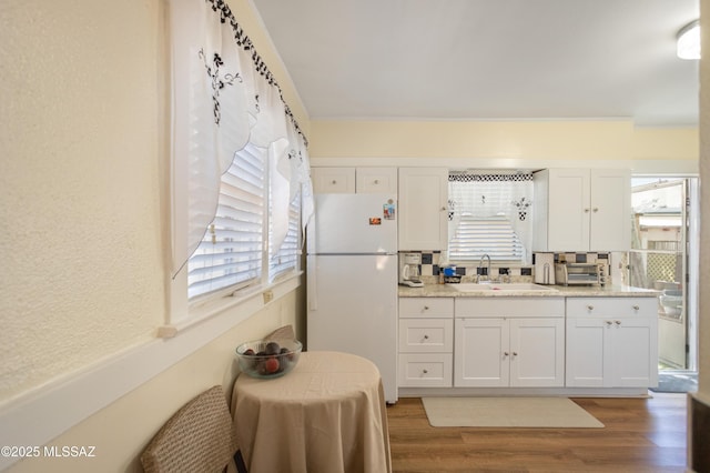 24 Black Knob, Bisbee, AZ 85603 - kitchen featuring freestanding refrigerator, a sink, light wood-type flooring, white cabinets, and light stone counters