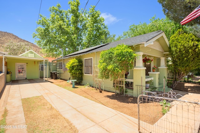 24 Black Knob, Bisbee, AZ 85603 - view of front of home with solar panels, a shingled roof, fence, and concrete driveway