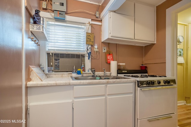 24 Black Knob, Bisbee, AZ 85603 - kitchen with white gas range, a sink, white cabinetry, light countertops, and wood finished floors