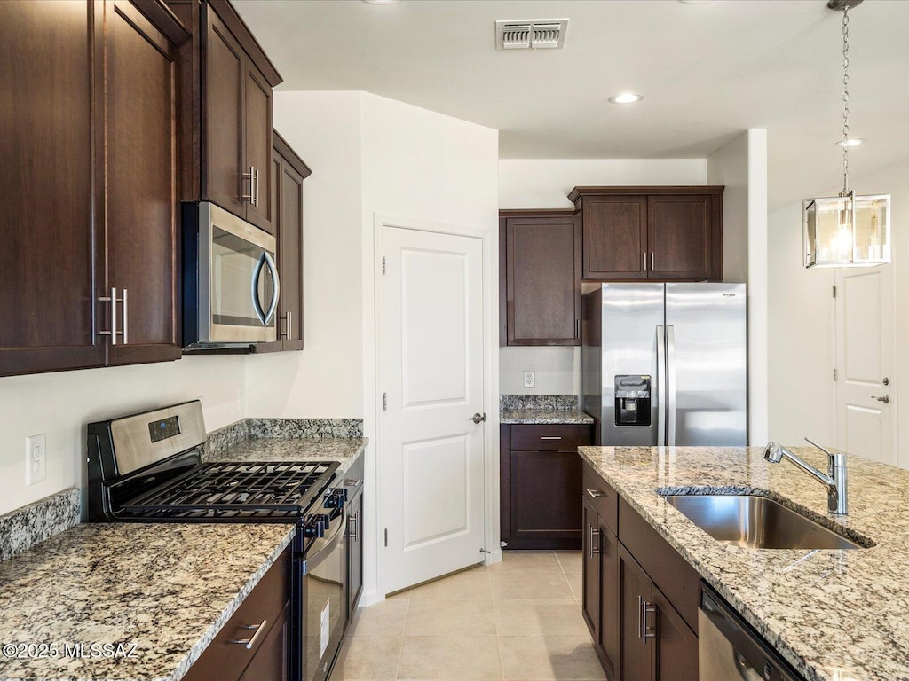 6818 E Via Del Cantillo, Tucson, AZ 85756 - kitchen featuring appliances with stainless steel finishes, a sink, dark brown cabinets, light tile patterned floors, and light stone counters