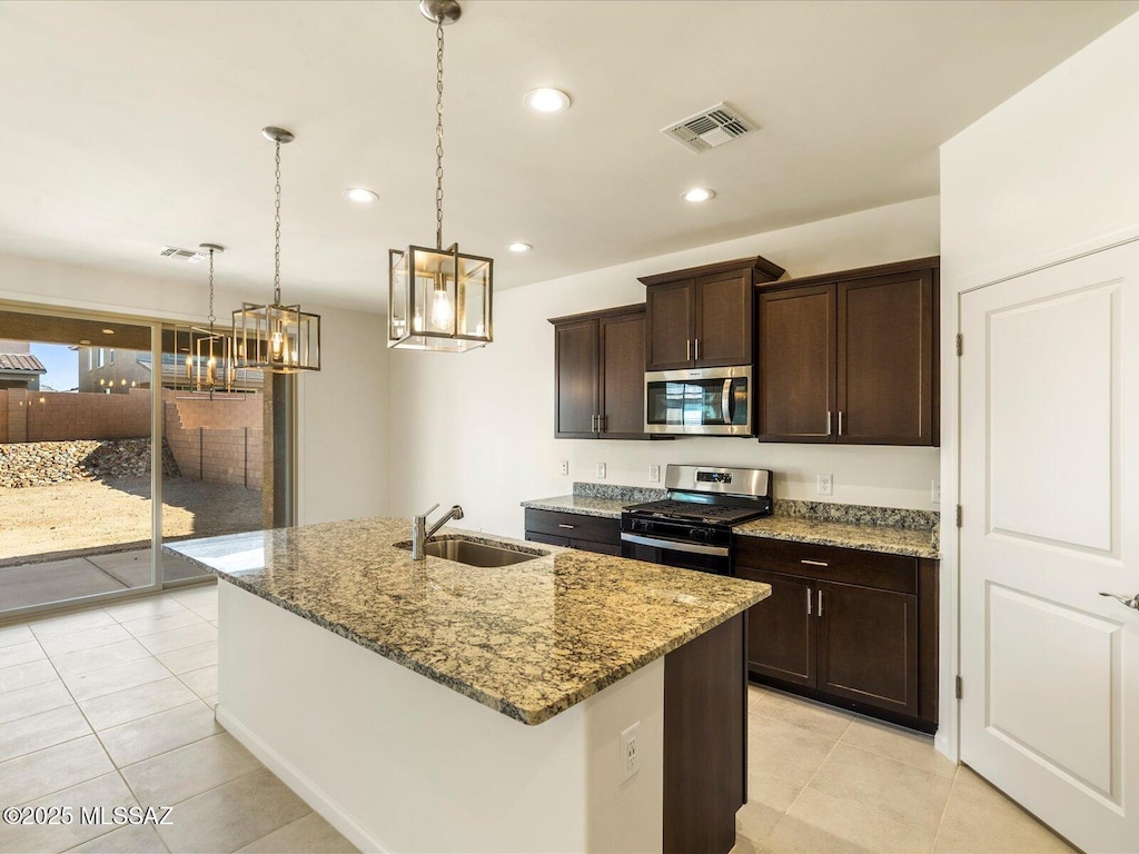 6818 E Via Del Cantillo, Tucson, AZ 85756 - kitchen with appliances with stainless steel finishes, a sink, a chandelier, light stone counters, and light tile patterned floors