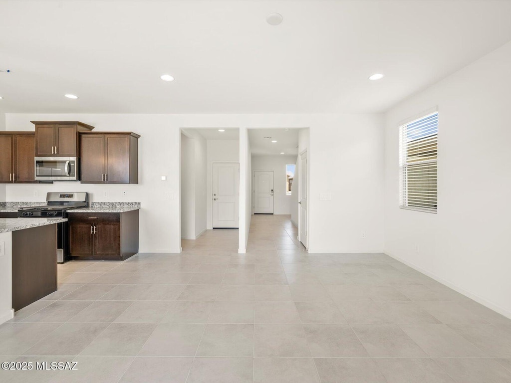 4743 E Julian Wash Dr, Tucson, AZ 85706 - kitchen featuring appliances with stainless steel finishes, light tile patterned floors, recessed lighting, dark brown cabinetry, and light stone countertops