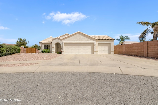 9429 N Elan Ln, Tucson, AZ 85742 - mediterranean / spanish-style home with a tiled roof, concrete driveway, a garage, and fence