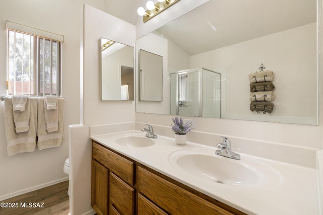 9429 N Elan Ln, Tucson, AZ 85742 - bathroom with a stall shower, wood finished floors, toilet, double vanity, and baseboards