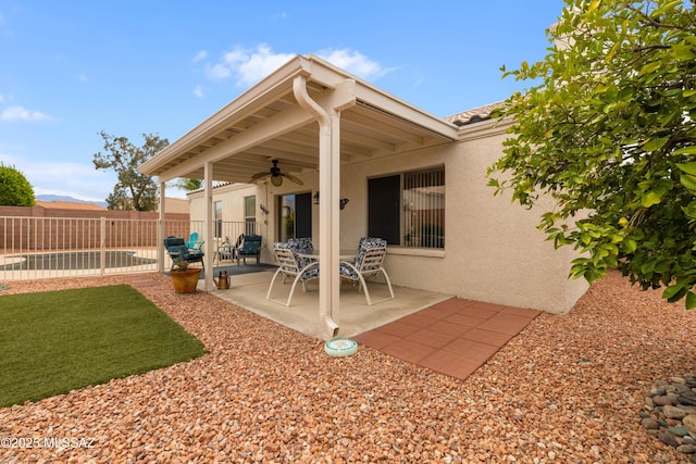 9429 N Elan Ln, Tucson, AZ 85742 - back of house featuring a ceiling fan, stucco siding, a patio, and fence