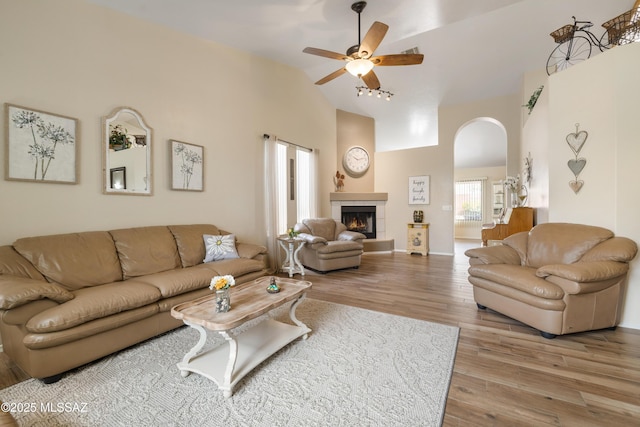 9429 N Elan Ln, Tucson, AZ 85742 - living area featuring high vaulted ceiling, ceiling fan, arched walkways, wood finished floors, and a fireplace