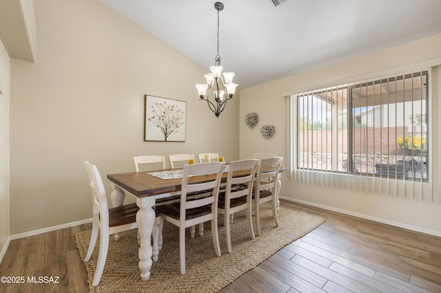 9429 N Elan Ln, Tucson, AZ 85742 - dining space with a chandelier, lofted ceiling, baseboards, and wood finished floors