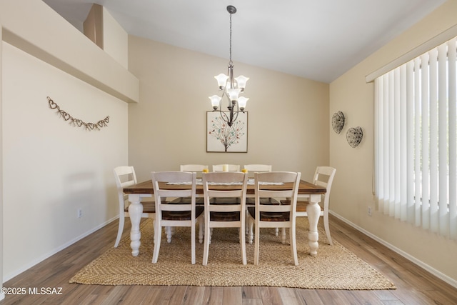9429 N Elan Ln, Tucson, AZ 85742 - dining area with wood finished floors, a chandelier, baseboards, and lofted ceiling