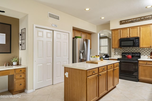 368 W Sacaton Canyon Dr, Oro Valley, AZ 85755 - kitchen featuring black appliances, arched walkways, light tile patterned floors, tasteful backsplash, and light countertops