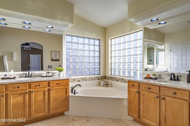 368 W Sacaton Canyon Dr, Oro Valley, AZ 85755 - bathroom featuring two vanities, tile patterned floors, a bath, and vaulted ceiling