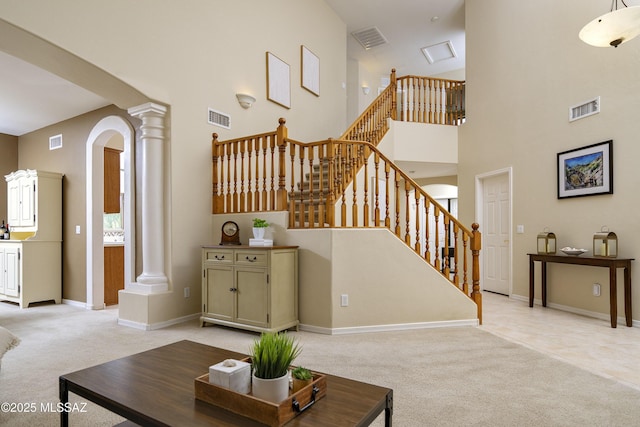 368 W Sacaton Canyon Dr, Oro Valley, AZ 85755 - living room featuring ornate columns, light carpet, stairway, and a high ceiling