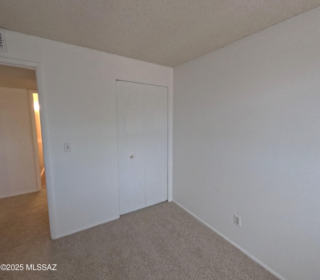 6509 E 39th St, Tucson, AZ 85730 - unfurnished bedroom with carpet flooring, a closet, and a textured ceiling