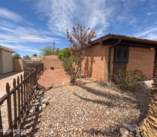 6509 E 39th St, Tucson, AZ 85730 - view of side of property featuring brick siding, fence, and an outbuilding