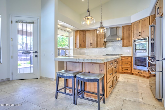 218 W Milbrae Springs Dr, Oro Valley, AZ 85755 - kitchen with appliances with stainless steel finishes, wall chimney exhaust hood, decorative backsplash, a sink, and a kitchen breakfast bar