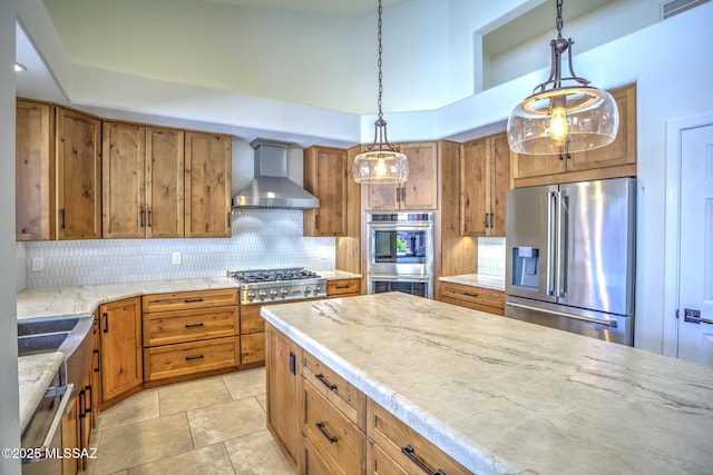 218 W Milbrae Springs Dr, Oro Valley, AZ 85755 - kitchen featuring stainless steel appliances, wall chimney exhaust hood, brown cabinets, and decorative backsplash